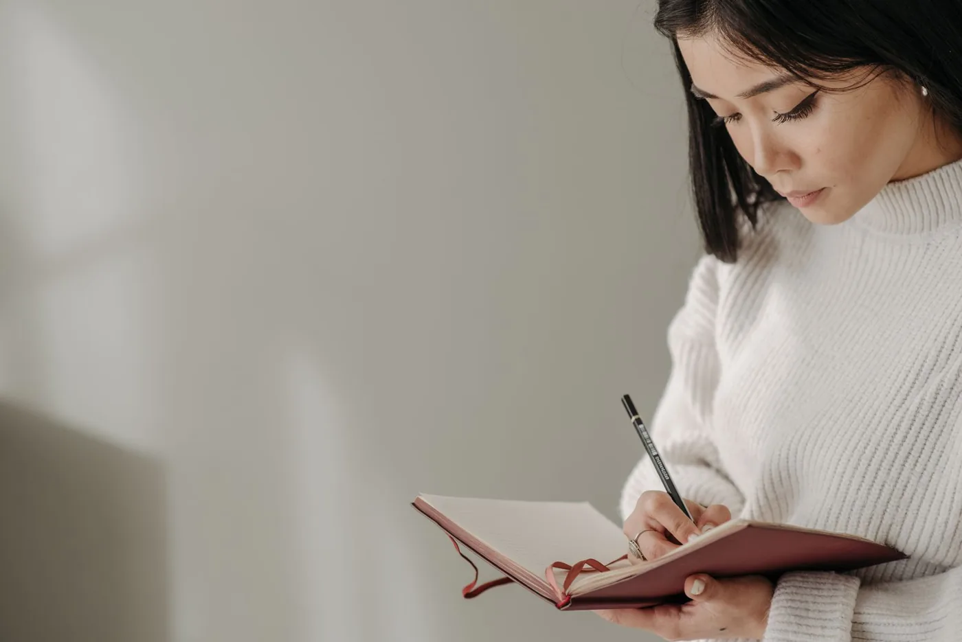 Người phụ nữ ghi chép vào sổ tay khi đọc